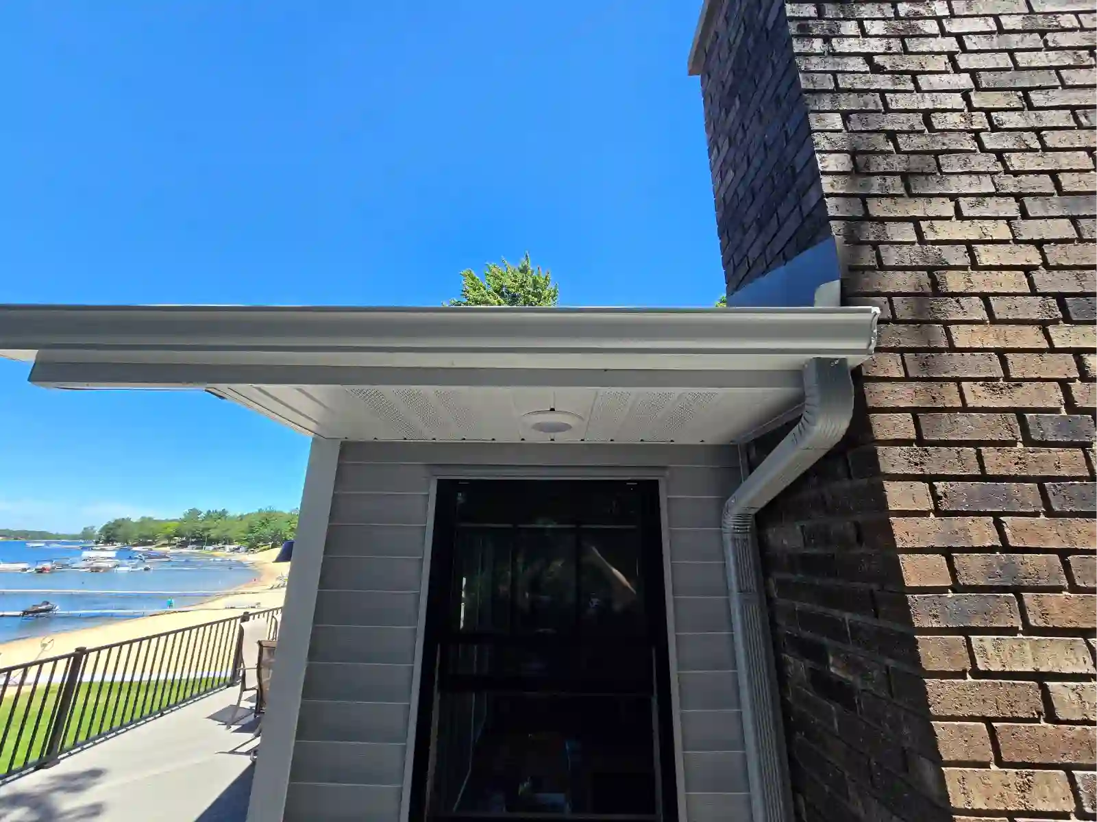 White gutter and downspout on a home overlooking a Northern Michigan lake